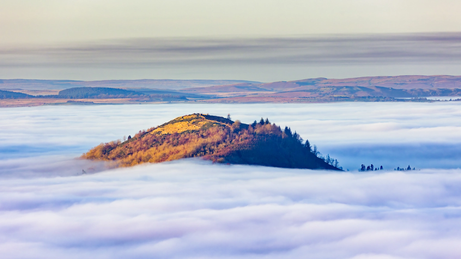Hills emerging from a dense fog at dusk in the Brecon Beacons, Wales, UK. Hills emerging from a dense fog at dusk in the Brecon Beacons, Wales, UK.